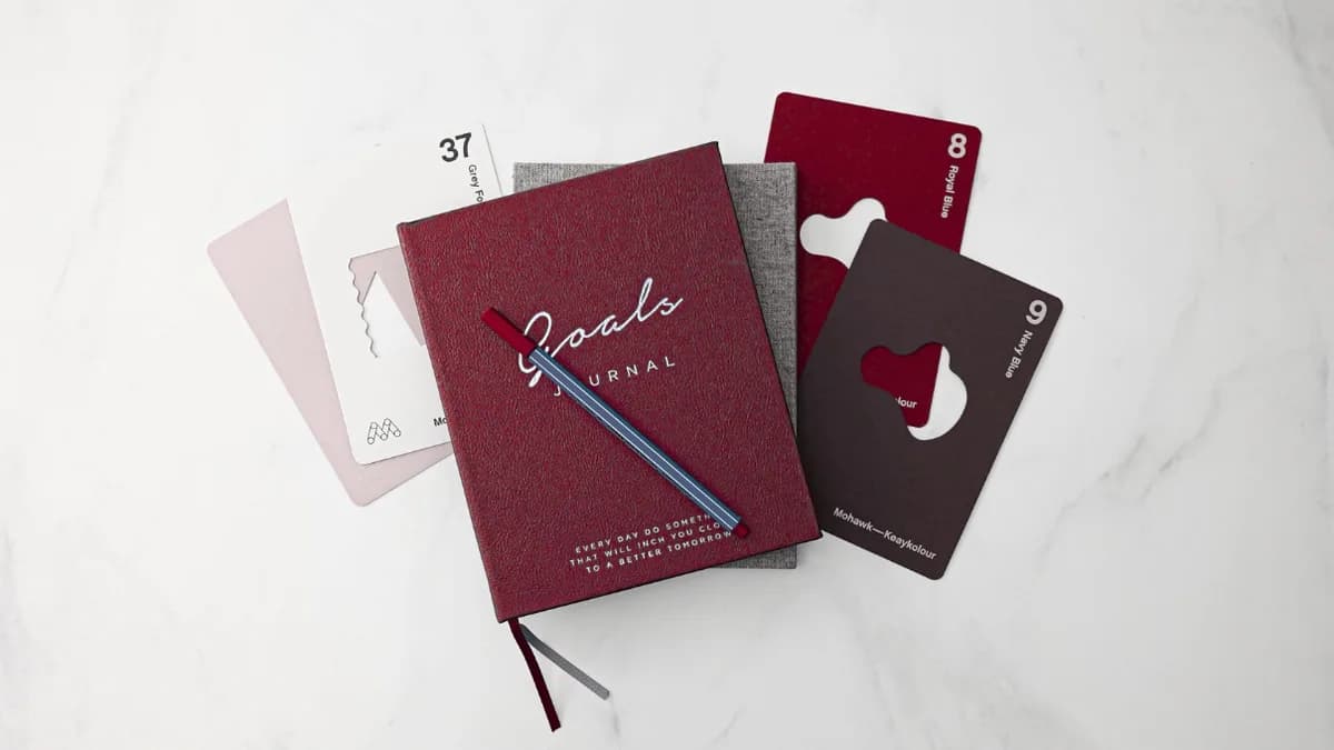 A branded journal and cards on a marble surface