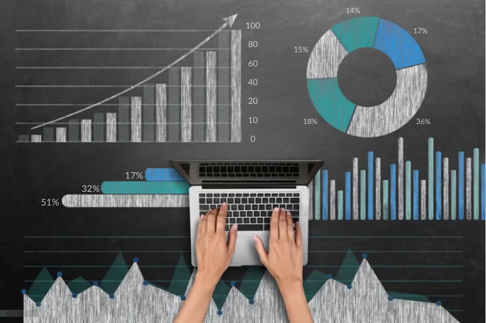 Hands typing on a laptop surrounded by chalk charts