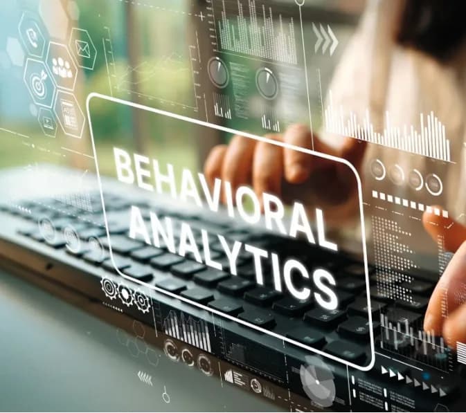 A keyboard under a glowing Behavioral Analytics display