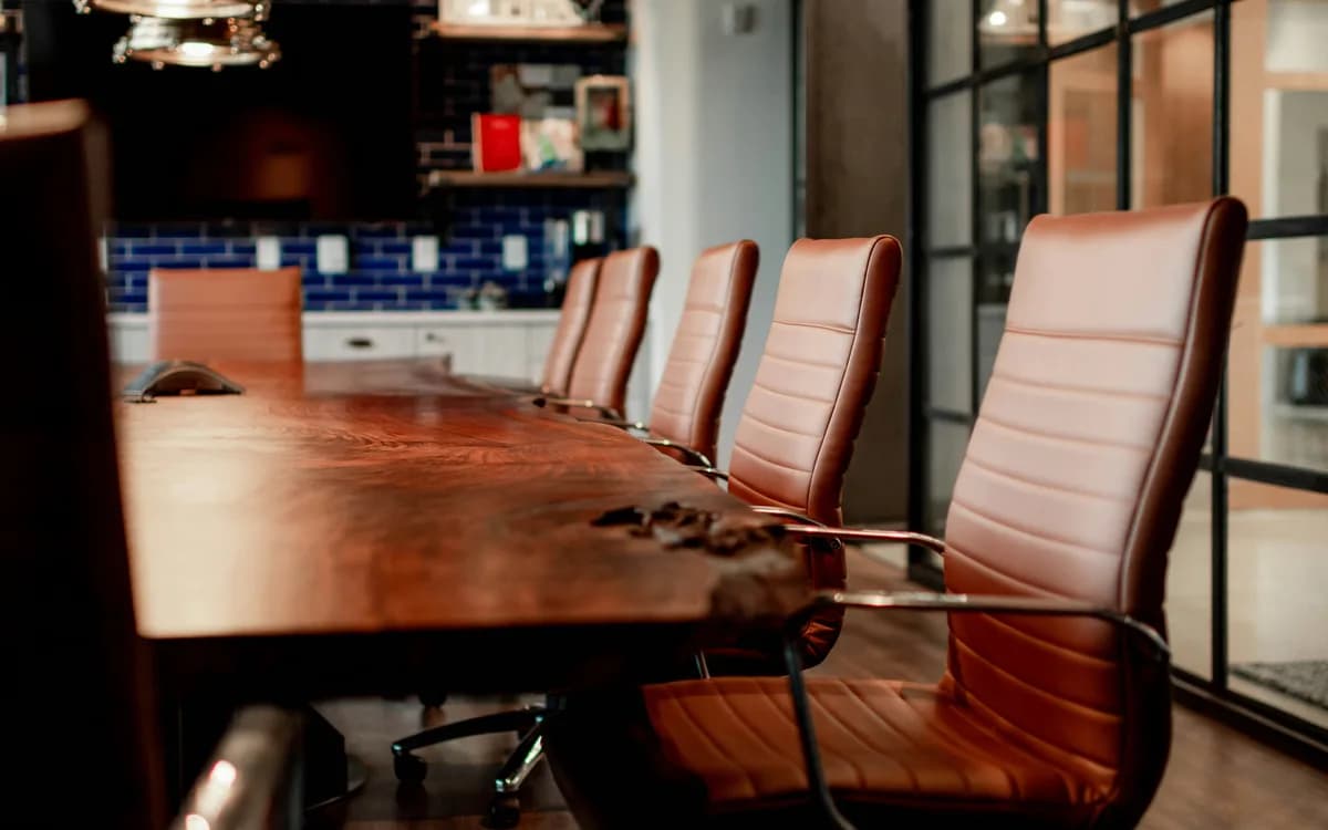 Leather chairs along a long wooden boardroom table