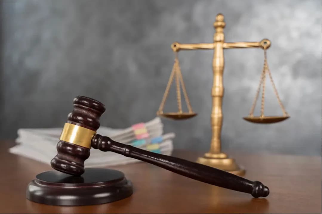 A gavel and brass scales of justice on a desk