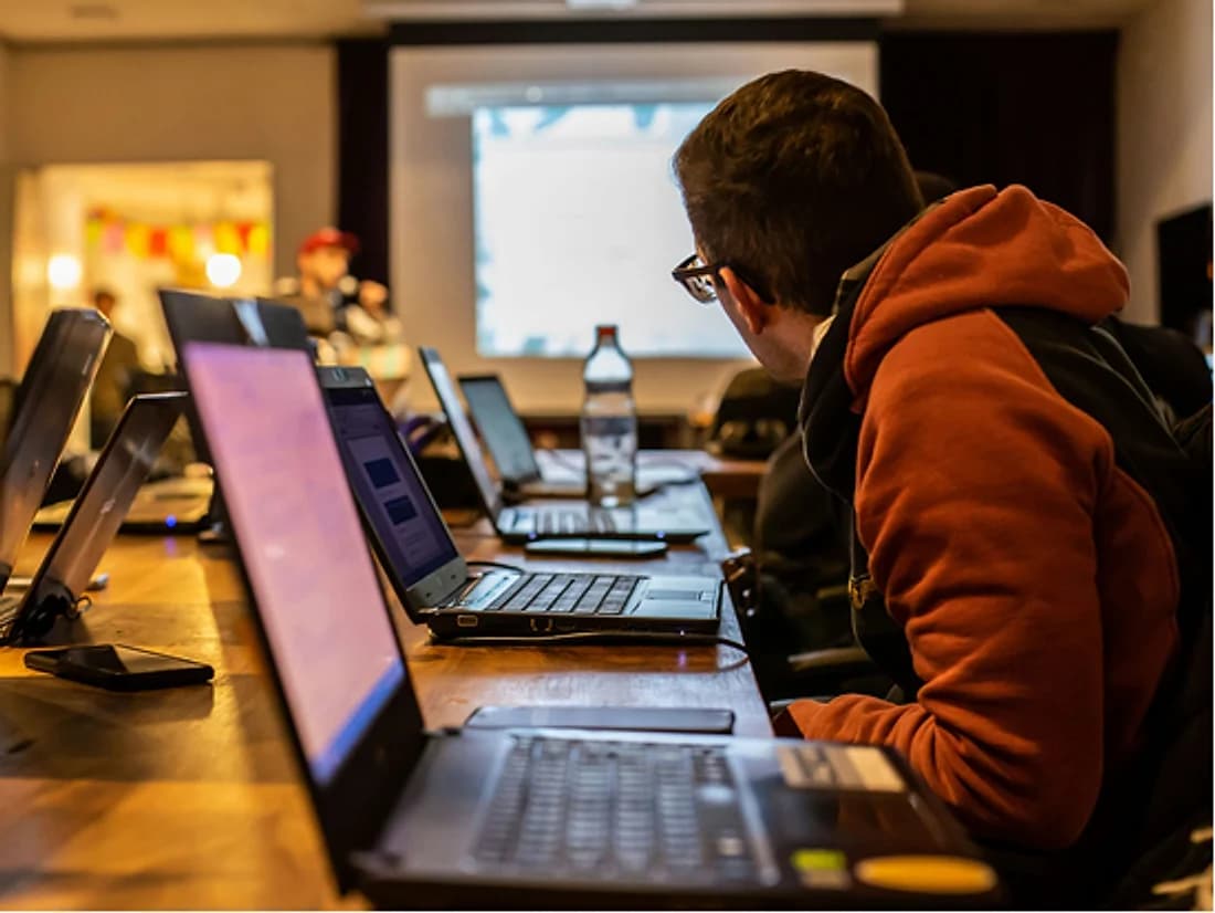 Trainees working on laptops in a training room