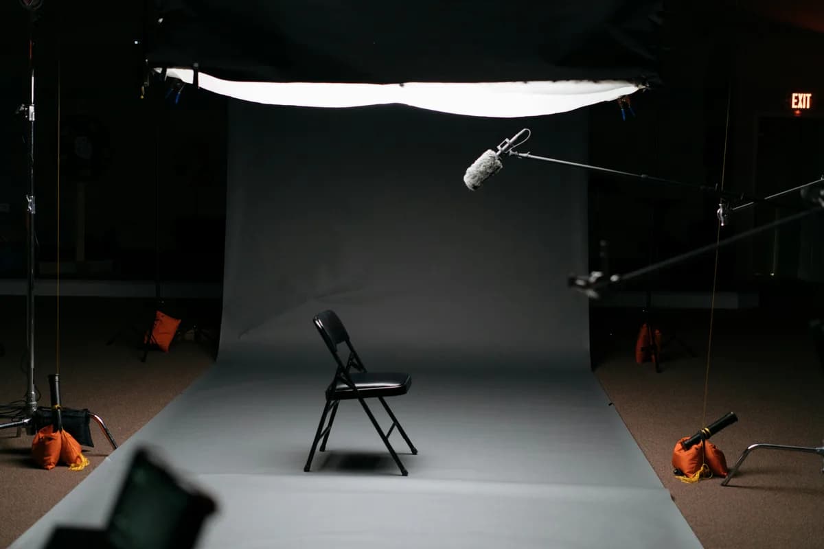 An empty chair under studio lights and a boom microphone