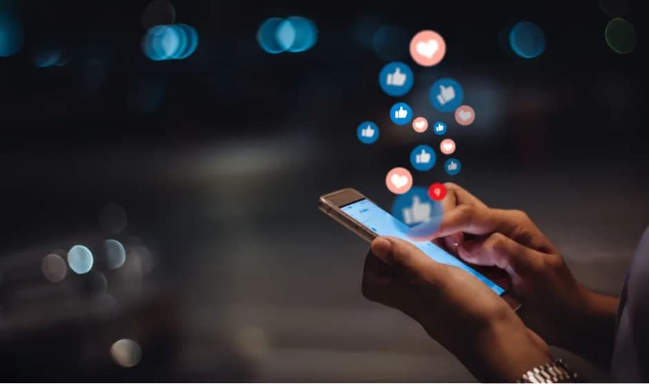 Like and heart icons rising from a smartphone at night