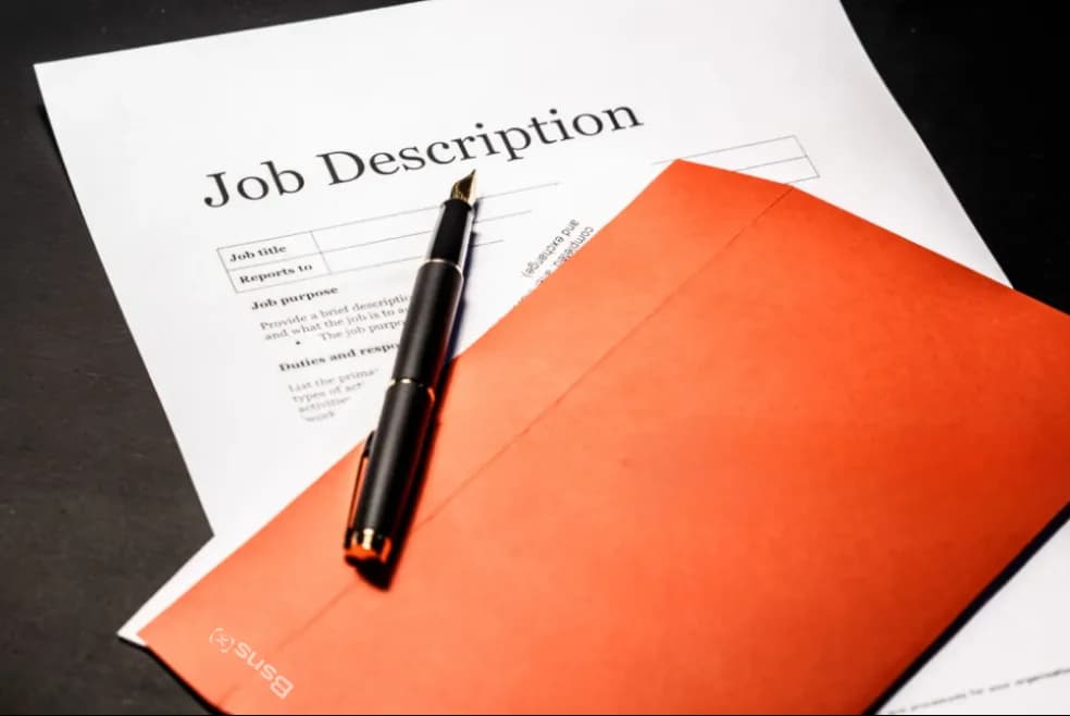 A job description form and a fountain pen on a Business X envelope