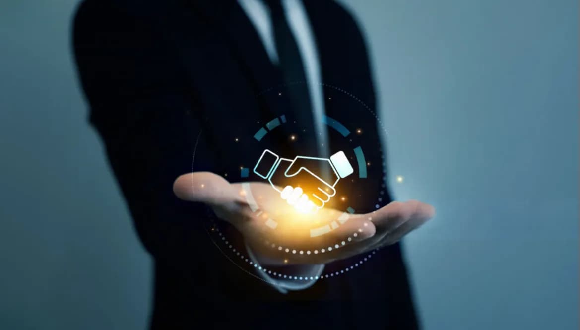 An open hand holding a glowing handshake icon